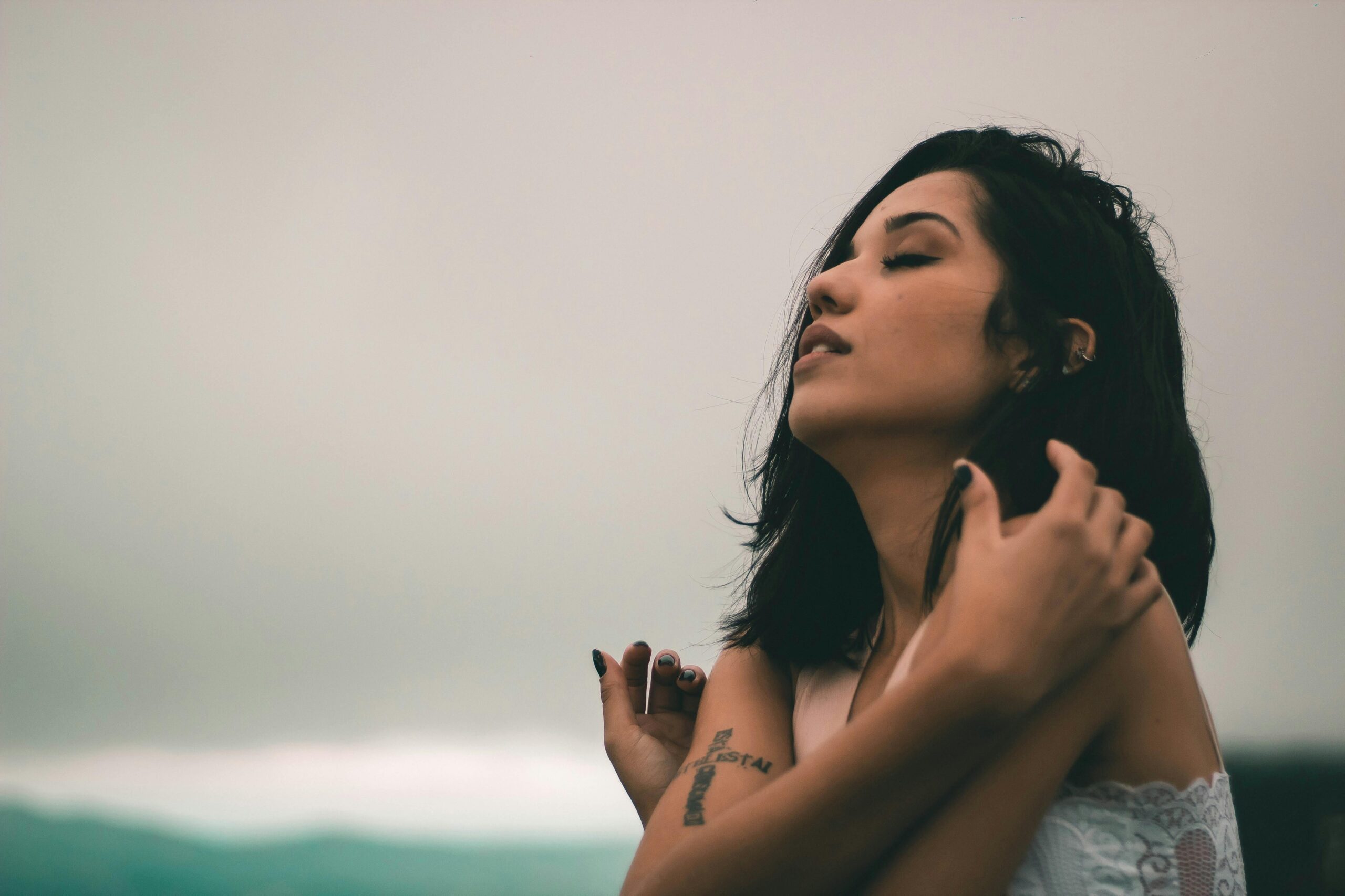 A woman practicing energy protection, wrapped in her arms, feeling safe and secure.