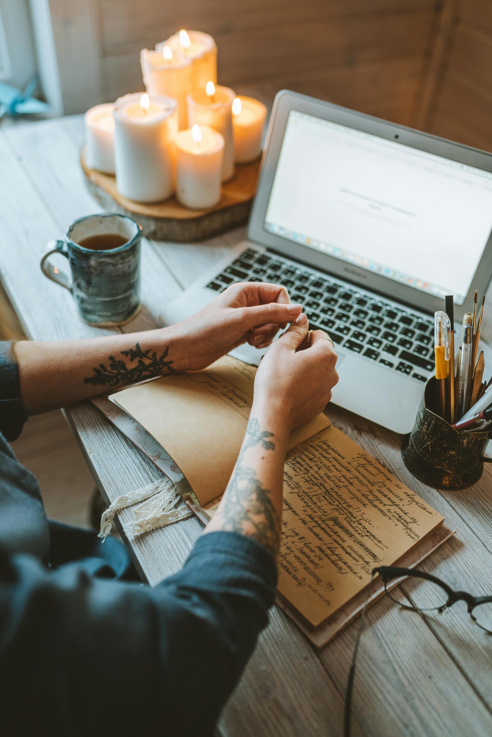 Workspace with candles, crystals, laptop, and journal to align with Financial Frequency for manifesting wealth.