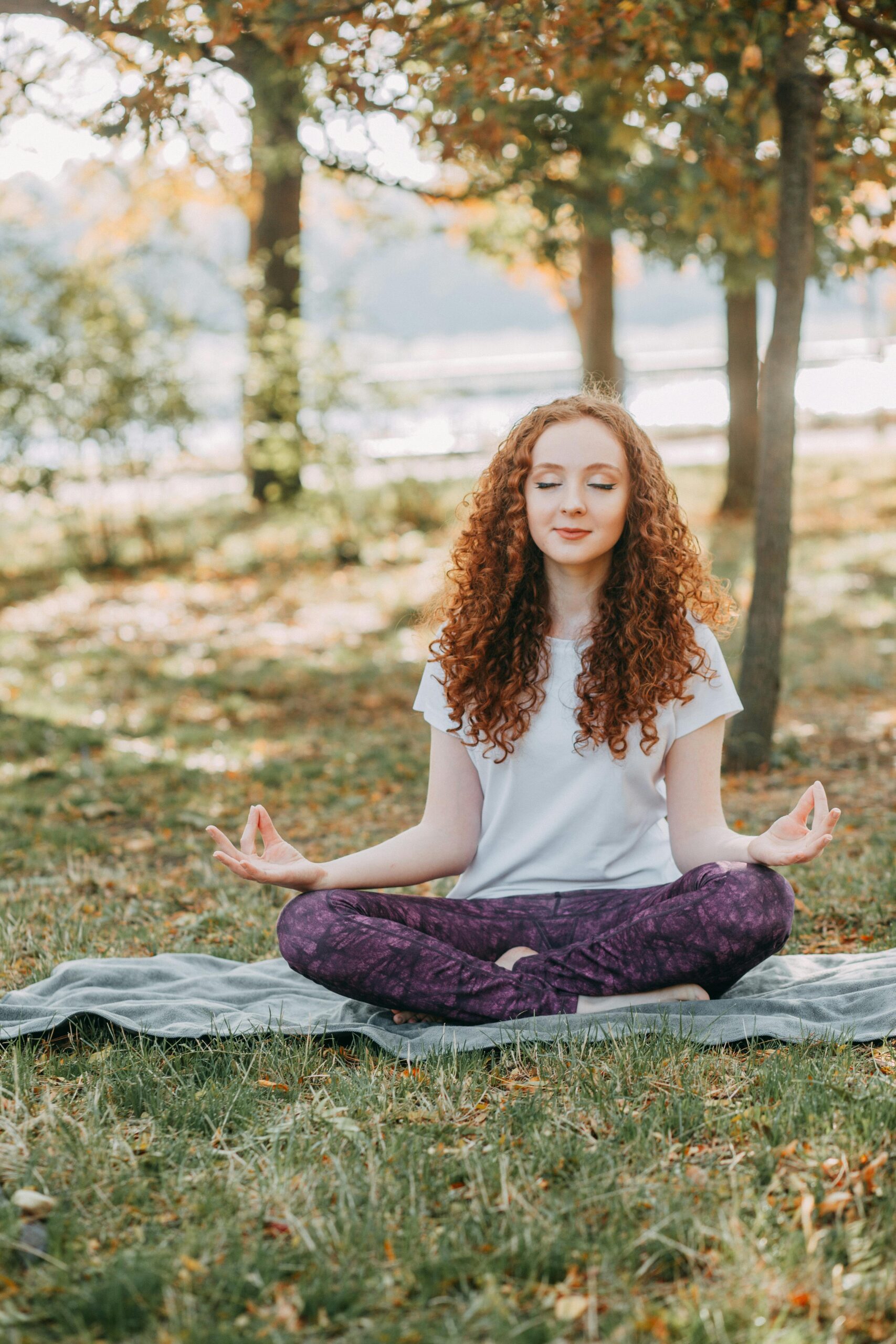 A woman meditating in nature, practicing mindfulness for money mindset.