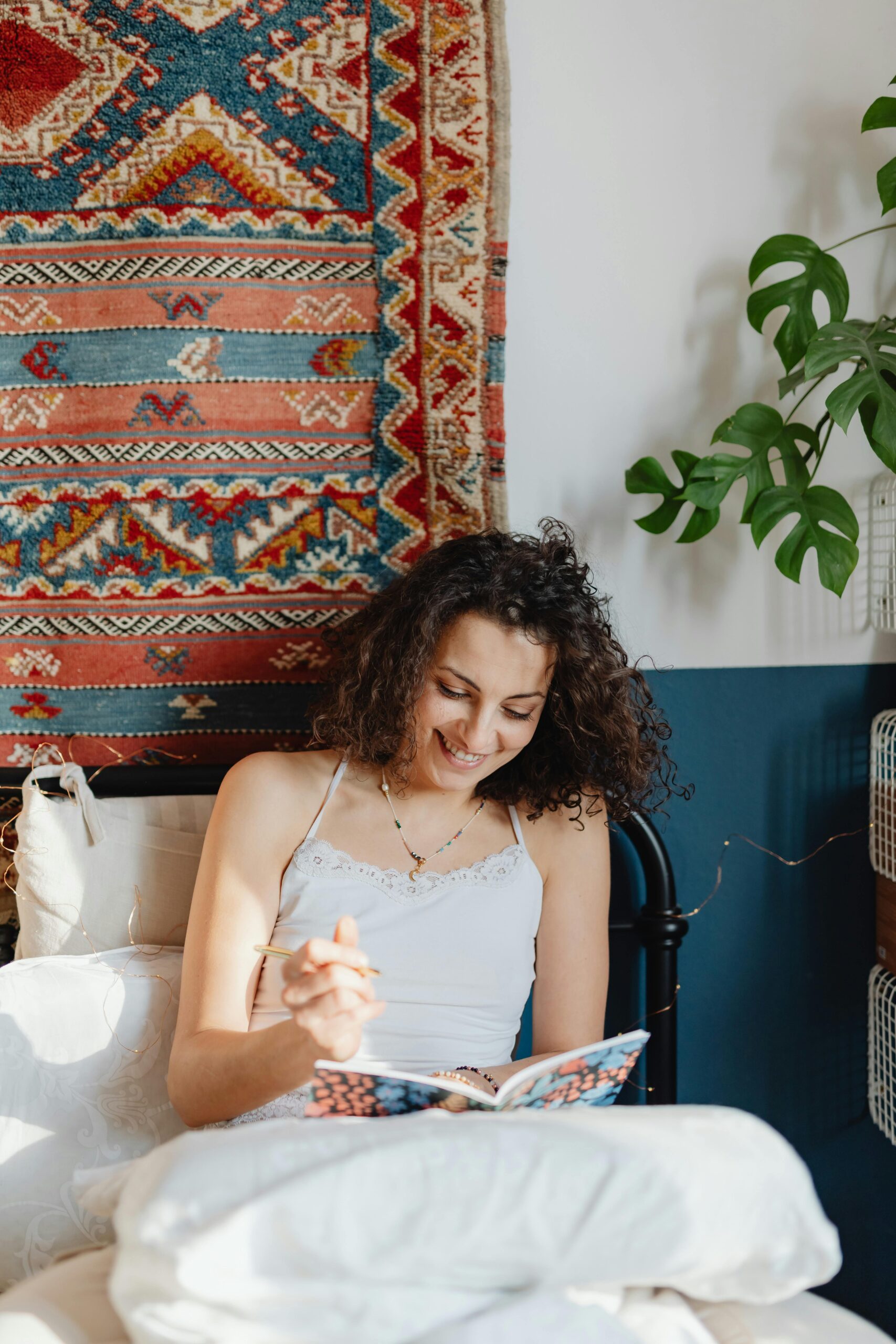 A woman sitting with her journal, smiling with gratitude, symbolizing alignment with the universe and the power of gratitude in manifestation.